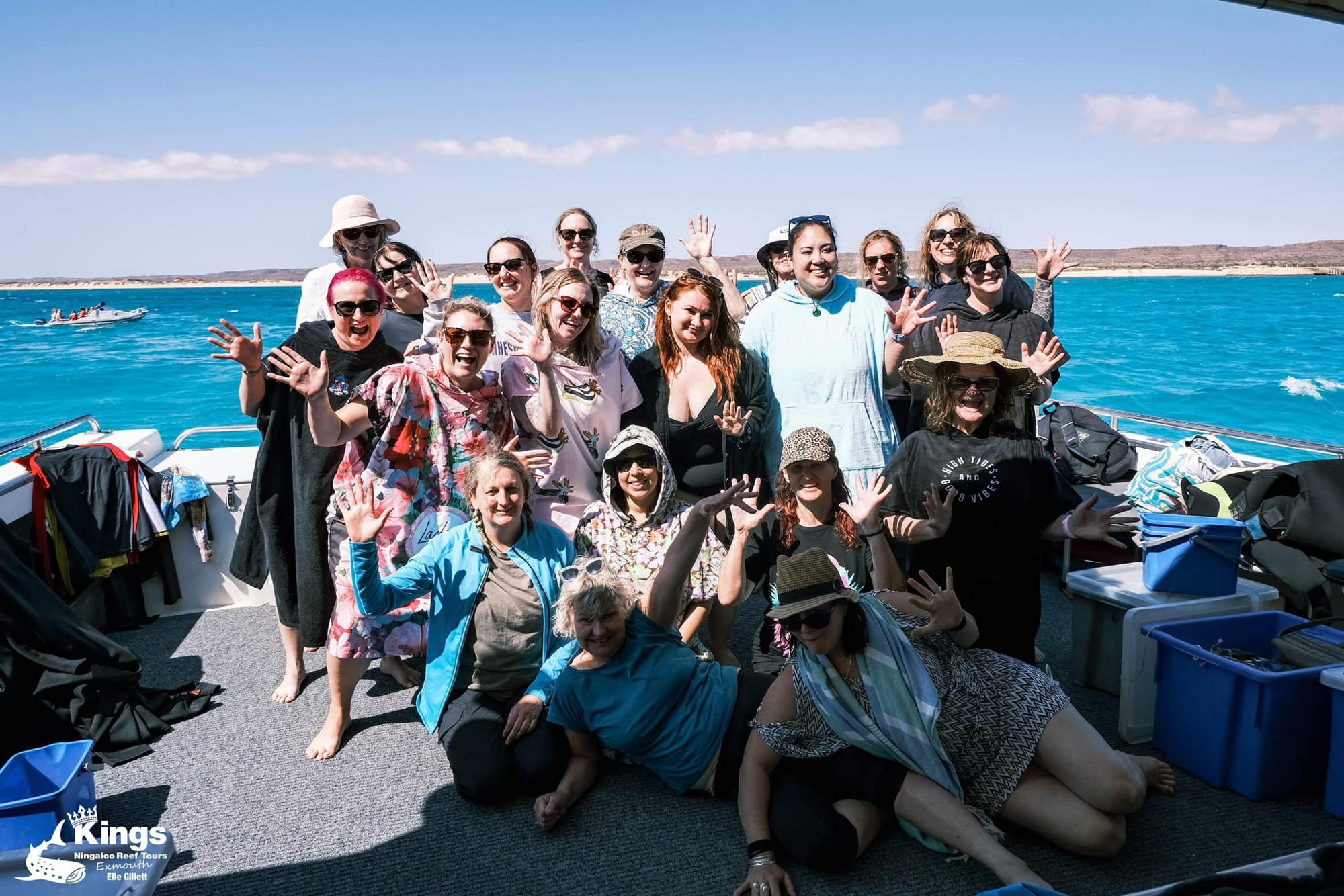 A big group of Ladies HQ women waving on the eco tour boat